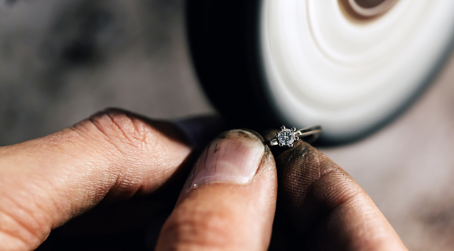 Guldsmed som arbetar med en ring