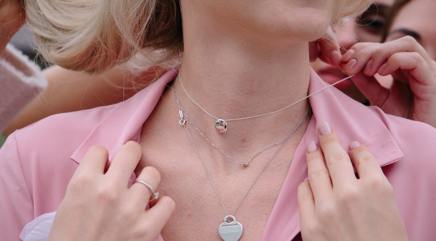 kvinna med flera halsband silver
